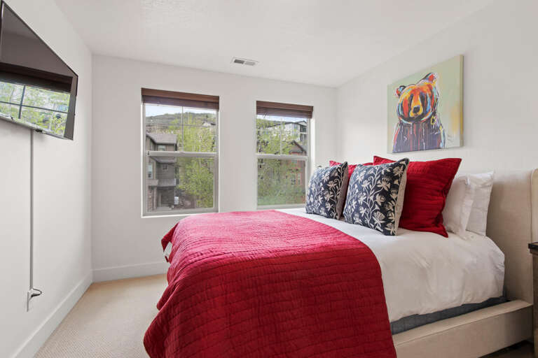 Sink into plush linens and wake to natural light streaming through your windows. The vibrant artwork and cozy bedding create a welcoming retreat for restful nights.