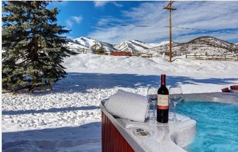 Soak in the hot tub with wine and snow-capped mountains stretching before you—pure mountain magic on a crisp winter day.