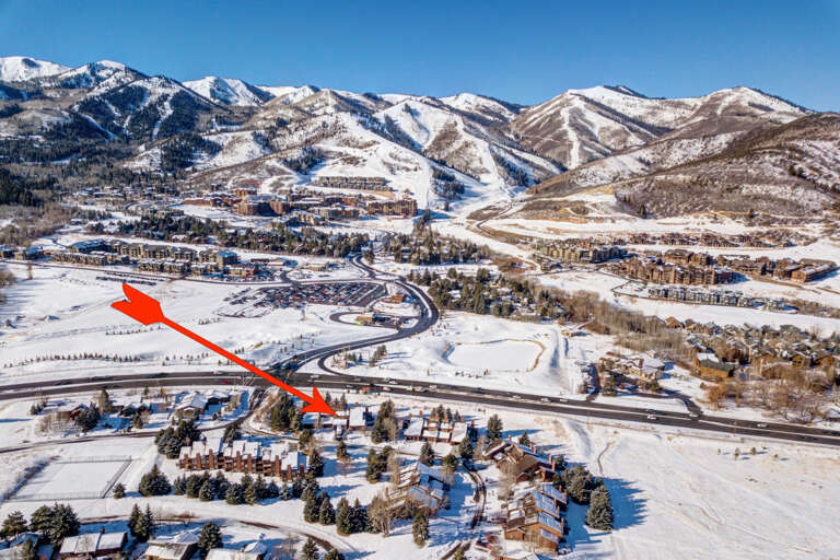 Aerial view of a winter vacation rental community nestled in a snowy mountain valley, with nearby ski slopes and convenient access to outdoor recreation and resort amenities.
