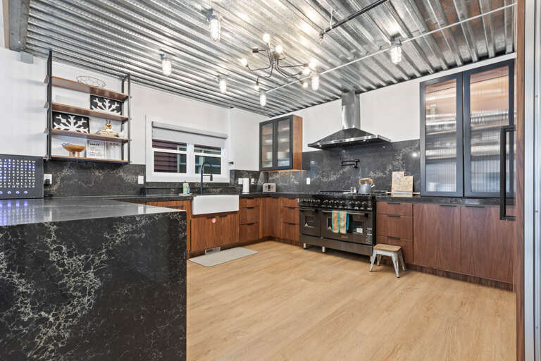 Fully Equipped Kitchen: Gas range, cabinetry, black quartz countertops.