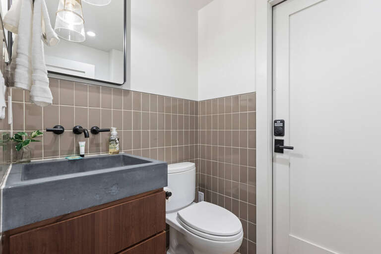 Modern bathroom with sleek black fixtures, elegant tile work, and a spa-like stone sink where you'll refresh each morning in style.