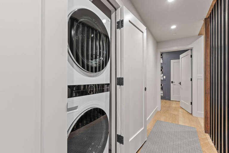 Your private laundry area features a modern stacked washer and dryer tucked neatly into a bright hallway closet, making it easy to keep your clothes fresh during your stay.