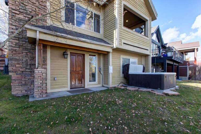 A comfortable mountain retreat featuring private hot tub access, multiple balconies, and stone accents set among autumn foliage, close to local attractions.