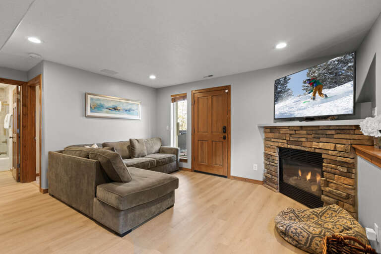 Unwind in your cozy living room, where a plush sectional, warm fireplace, and large TV create the perfect space for après-ski relaxation.