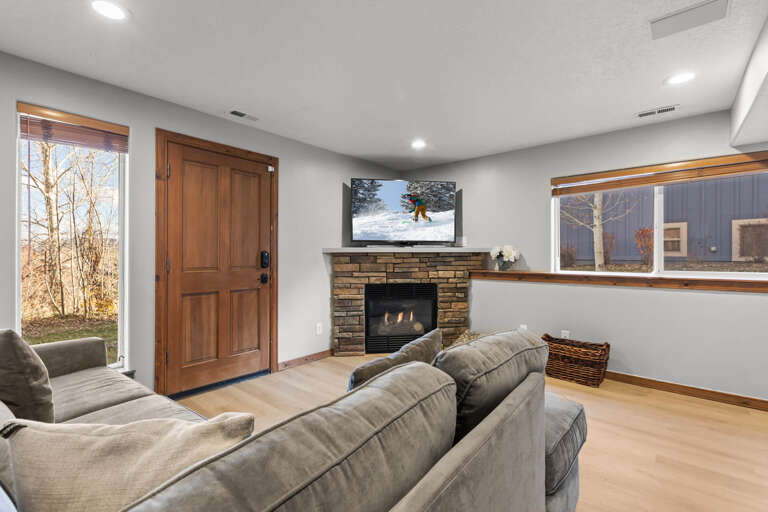 Sink into plush seating as your own fireplace warms your retreat, with large windows framing scenic views and a flat-screen TV ready for movie nights or après-ski relaxation.