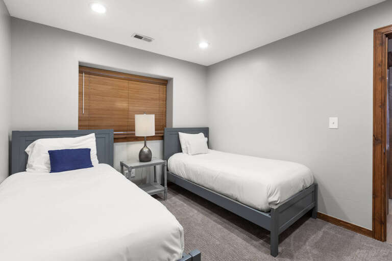 Slip into crisp linens in this peaceful twin bedroom, where soft lighting and calm tones invite restful sleep after your day's adventures.