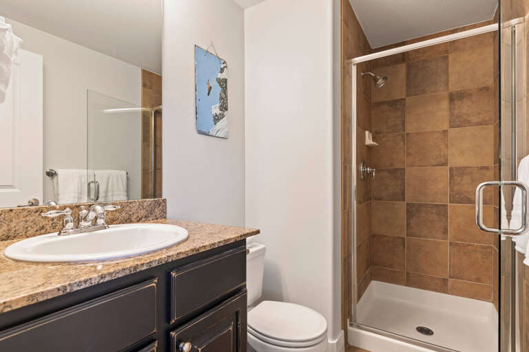 Step into your private bathroom, where granite counters and a sleek glass-enclosed shower welcome you after a day of adventure. Fresh towels and mountain-inspired art add a cozy, refreshing touch.