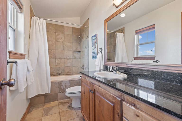 Bear Hollow 5482: Sleek sink, mirror, toilet, and convenient tub shower combo.