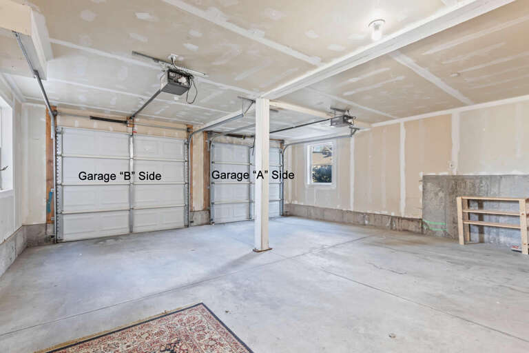 Spacious two-car garage with ample storage potential, featuring dual automatic door openers for easy vehicle access and additional space for equipment or hobbies.