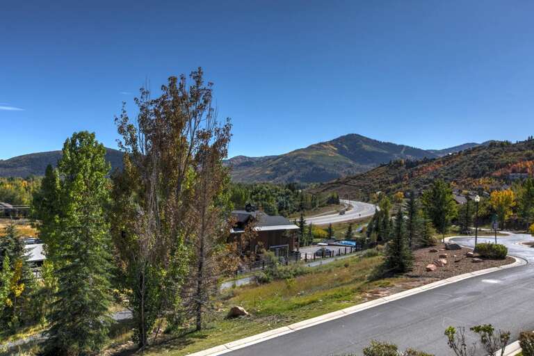 Nestled in a scenic mountain community with autumn foliage dotting the landscape and winding roads leading to outdoor adventures nearby.