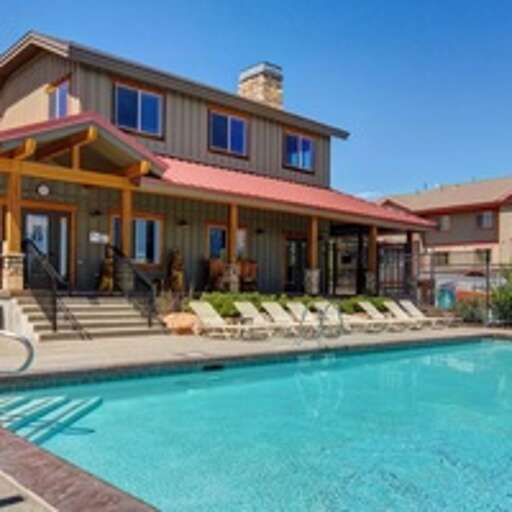 Pool beckons beneath bright skies. Lounge chairs invite you to soak up the sun while enjoying resort-style living steps from your spacious home.