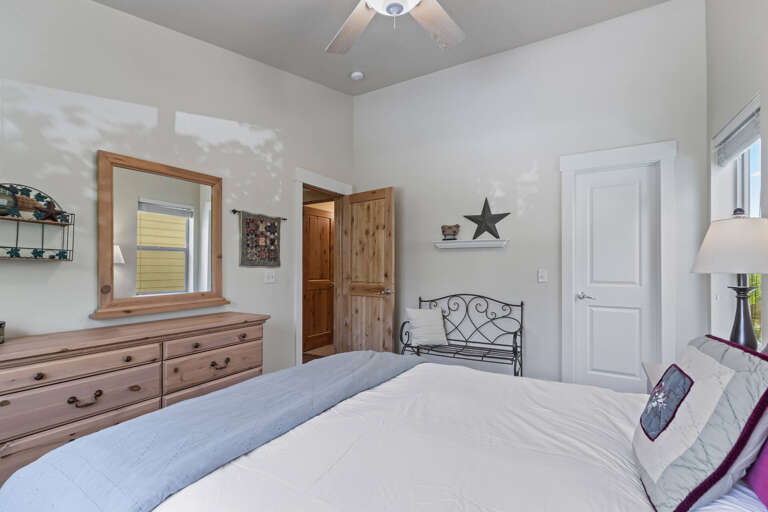 Unwind in your serene bedroom featuring soft linens, charming décor, a ceiling fan for comfort, and rustic touches that make you feel right at home.