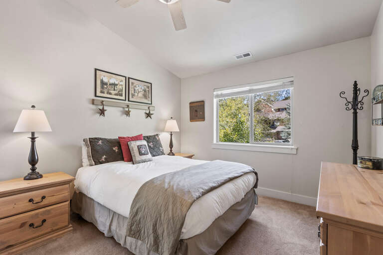 Relax in your cozy bedroom with a plush queen bed, soft linens, and a gentle ceiling fan—your peaceful retreat awaits after a day of adventure.