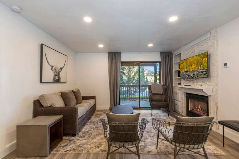 Cozy seating by fireplace, perfect for relaxing near outdoor patio. Cozy seating by fireplace, perfect for relaxing near outdoor patio.