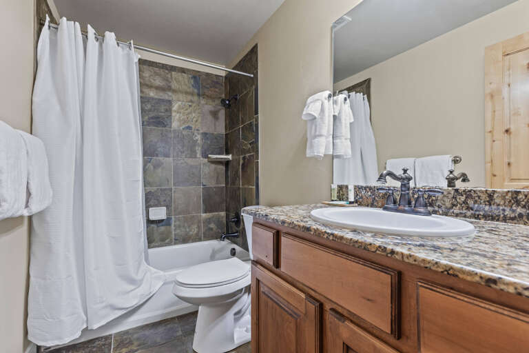 Sleek sink, mirror, toilet, and tub-shower combo in modern design. Sleek sink, mirror, toilet, and tub-shower combo in modern design.