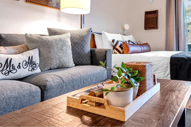 Cozy living space with sofa bed, queen bed, and center table.