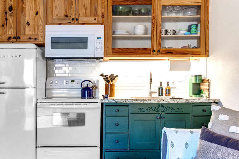 Cozy space with electric range, wood cabinets, and modern appliances. Cozy space with electric range, wood cabinets, and modern appliances.