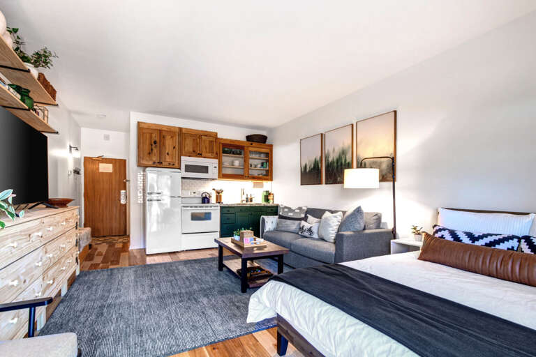 Cozy space with a sofa bed, center table, and kitchen area. Cozy space with a sofa bed, center table, and kitchen area.