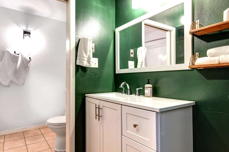 Sleek sink and mirror in a spacious, full bathroom oasis. Sleek sink and mirror in a spacious, full bathroom oasis.
