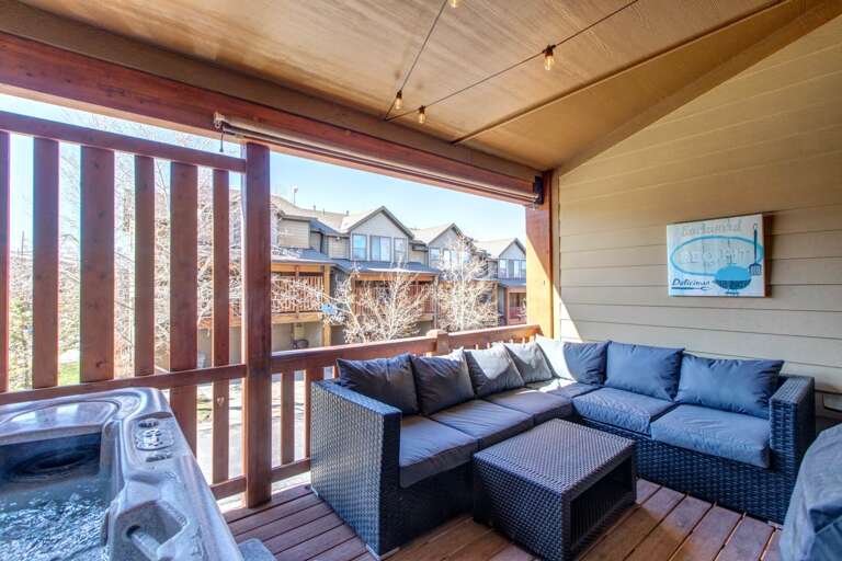Sink into plush outdoor seating on your private covered balcony, where a hot tub awaits and mountain air refreshes. Your perfect retreat for morning coffee or evening stargazing.