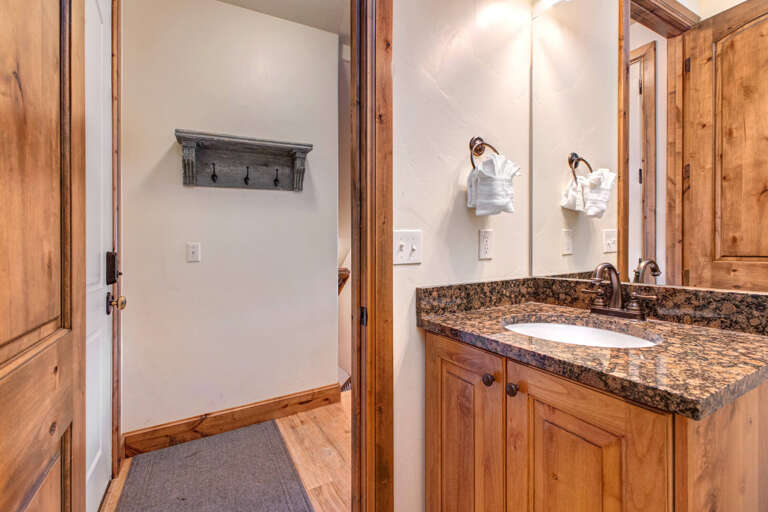 Your bathroom features a polished granite vanity, warm wood cabinetry, and fresh linens—a refined space to start each day feeling refreshed and ready.