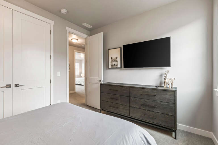 This peaceful bedroom offers the perfect retreat after a day of exploring, with soft linens, plenty of storage in the sleek dresser, and your own smart TV for entertainment.
