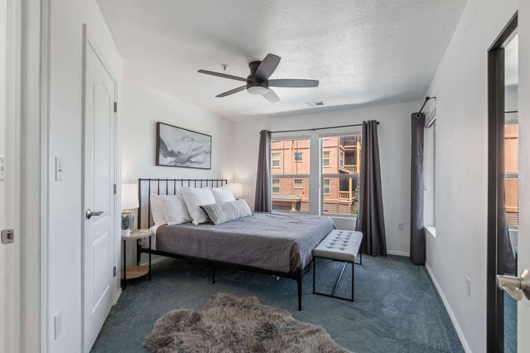 Cozy King bed next to a large window. Cozy King bed next to a large window.