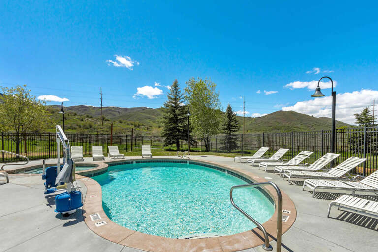 Sparkling pool with mountain views, loungers for soaking up the sun, and accessible features for easy entry—perfect for your relaxing getaway.