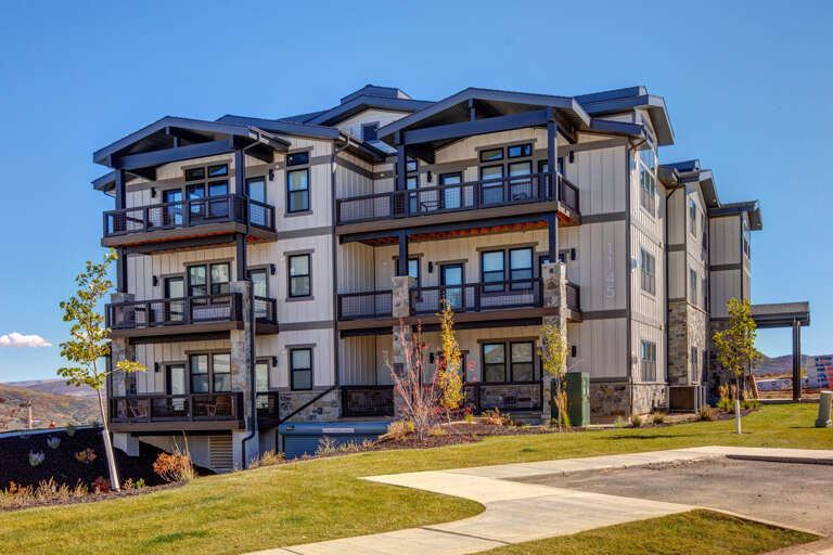 Modern multi-level vacation property featuring contemporary mountain architecture with stone accents, extensive balconies, and hillside setting surrounded by natural landscape.