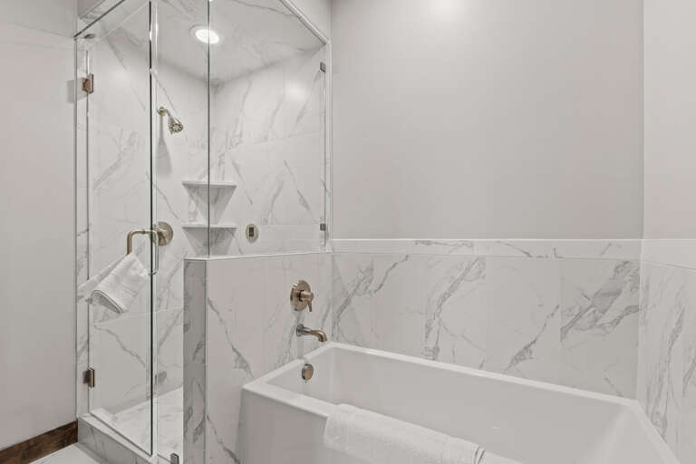 Luxurious marble surrounds your private sanctuary—step into a rainfall shower or soak in the elegant tub after a day exploring.