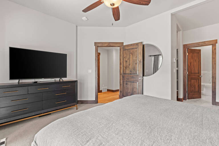 Unwind in your tranquil bedroom with a plush bed, modern entertainment, and elegant wood accents—your perfect escape awaits.