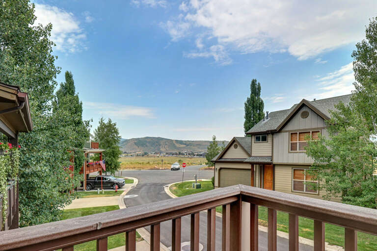 Quiet residential neighborhood with mountain backdrop and mature trees framing the property—a peaceful setting for your vacation stay.