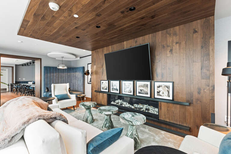Sink into plush seating beneath warm wood tones and admire the elegant fireplace—your cozy retreat after a day of adventure.