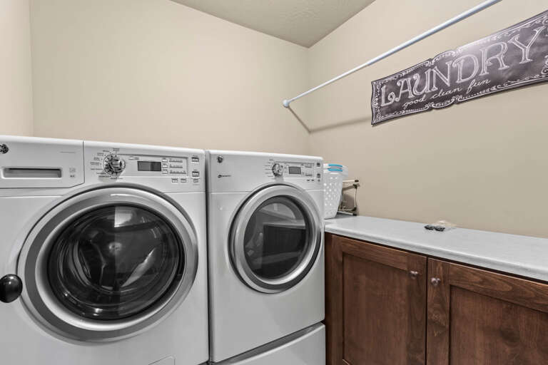 Your laundry room features modern front-loading washer and dryer, ample counter space for folding, and a convenient hanging rod—making chores effortless during your stay.
