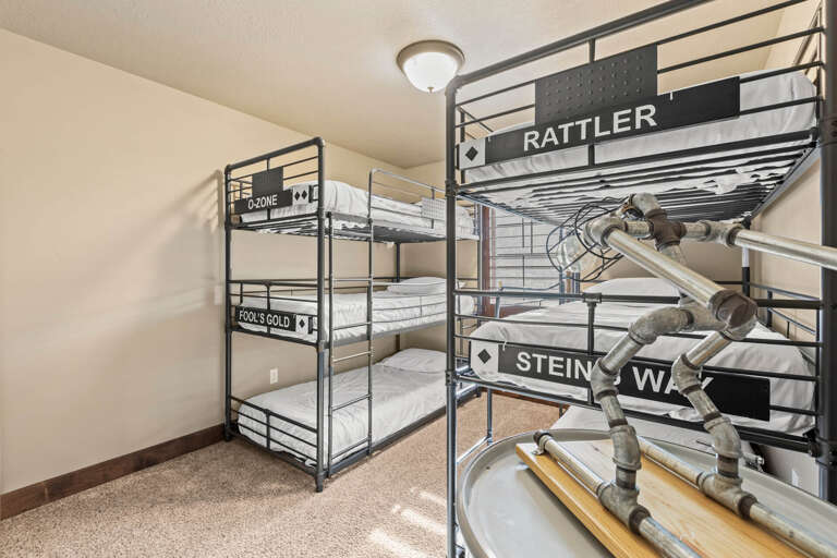 Gather your crew in this fun industrial-style bunkroom with themed street sign décor—perfect for kids or groups seeking a playful sleep space with plenty of sleeping spots.