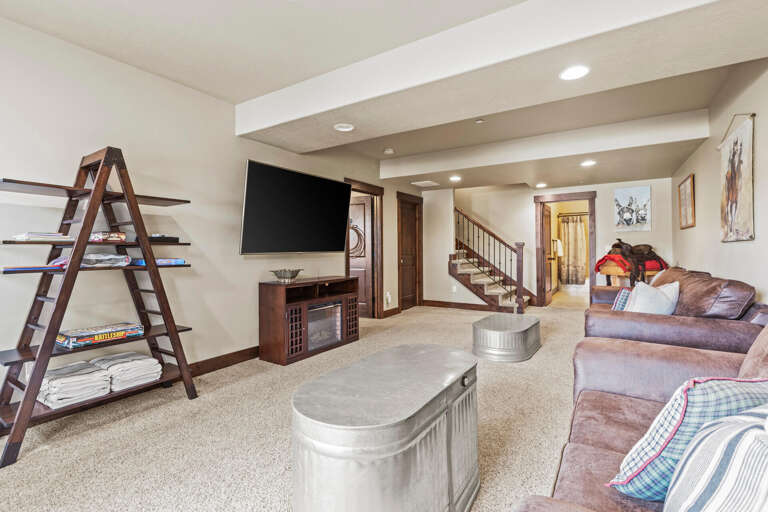 Sink into the plush leather sofas and enjoy a movie night on the big screen, or explore the rustic charm of the shelving—your perfect retreat for relaxation.