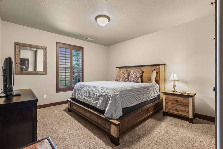 Step into your cozy bedroom, where rustic wood details and natural light create a peaceful retreat for your mountain getaway.