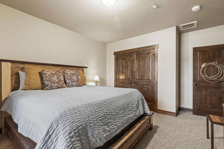 Unwind in your peaceful bedroom featuring a cozy bed dressed in soft linens, rustic wood accents, and warm lighting to help you drift into restful sleep.