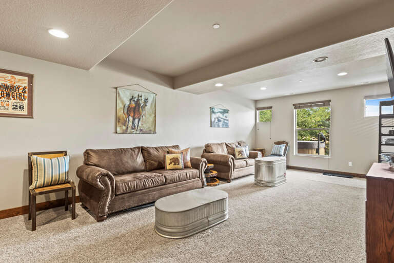 Unwind in your spacious living room, where rustic charm meets comfort. Sink into plush leather sofas, enjoy natural light from generous windows, and feel right at home with unique Western-inspired touches throughout.
