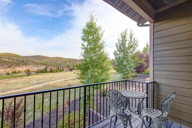 Balcony with mountain views and outdoor seating overlooking rolling hills and neighborhood scenery. A peaceful spot with natural surroundings and open-air ambiance.