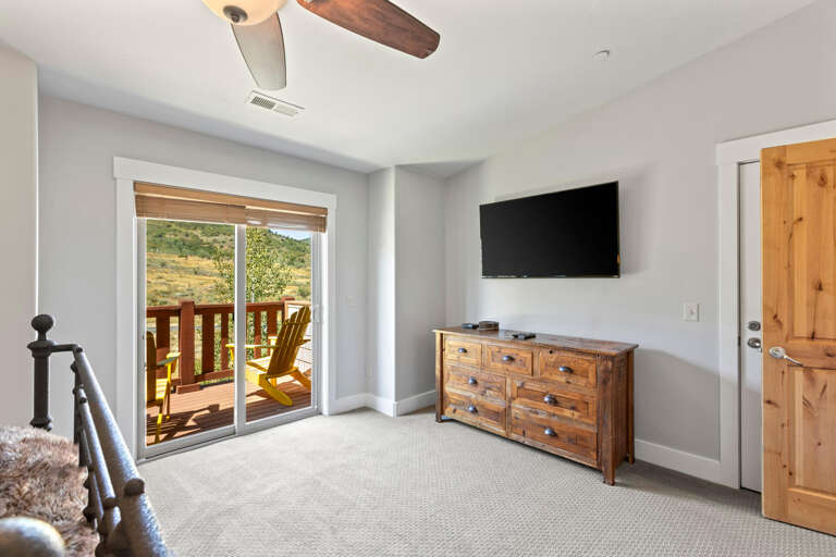 Wake to serene mountain views from your private bedroom, where rustic wood accents and a ceiling fan create a cozy retreat. Step onto your balcony to savor morning coffee in the fresh air.