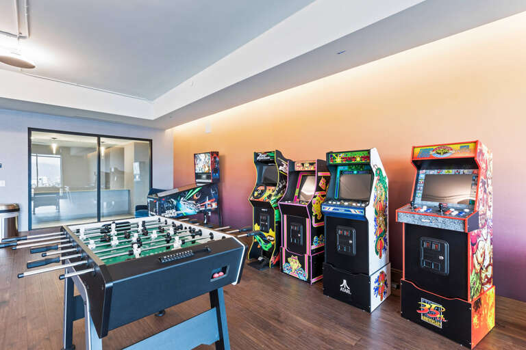 Challenge your group to a game night in this vibrant arcade room, featuring classic machines and foosball for endless fun and friendly competition.