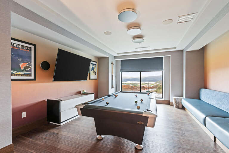 Challenge friends to a game at the billiards table while enjoying sweeping landscape views through floor-to-ceiling windows and entertainment on the mounted flat-screen TV.