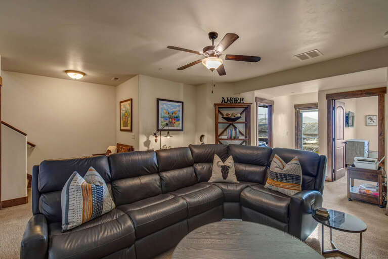 Sink into the plush leather sectional and unwind in your spacious living room, where ceiling fans keep you comfortable and thoughtful décor invites you to feel right at home.