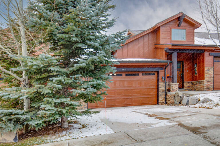 A beautiful mountain retreat surrounded by towering pines and aspen trees, offering winter charm and alpine ambiance in a peaceful neighborhood setting.