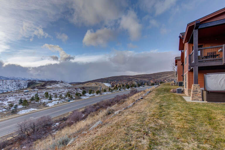Mountain-view property situated along a scenic road, with snow-dusted peaks and wide-open sky framing the surrounding landscape.