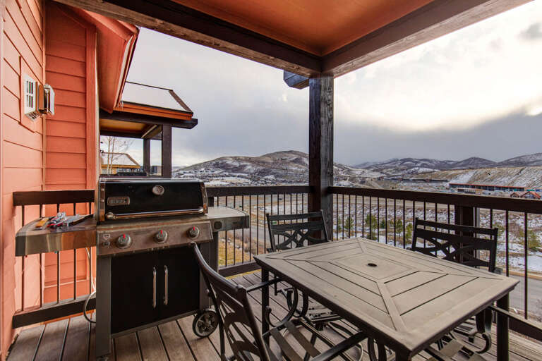 Step onto your private covered deck and take in breathtaking mountain vistas while grilling dinner. This outdoor space invites you to relax at the dining table and savor the peaceful winter landscape stretching before you.
