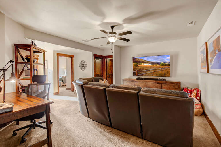 Sink into plush leather seating and unwind with your favorite shows on a large flat-screen TV. The open layout and warm wood accents create a welcoming space for relaxation.