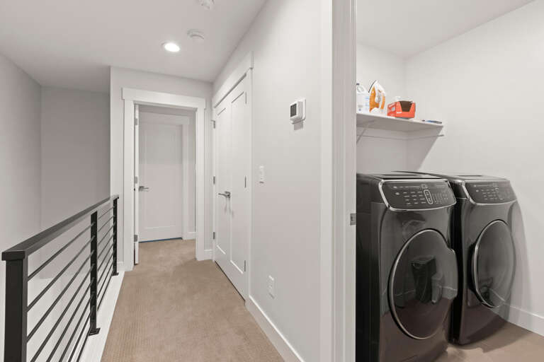 A modern laundry alcove features full-size washer and dryer for your convenience during your stay, ensuring you can pack light and refresh your wardrobe anytime.