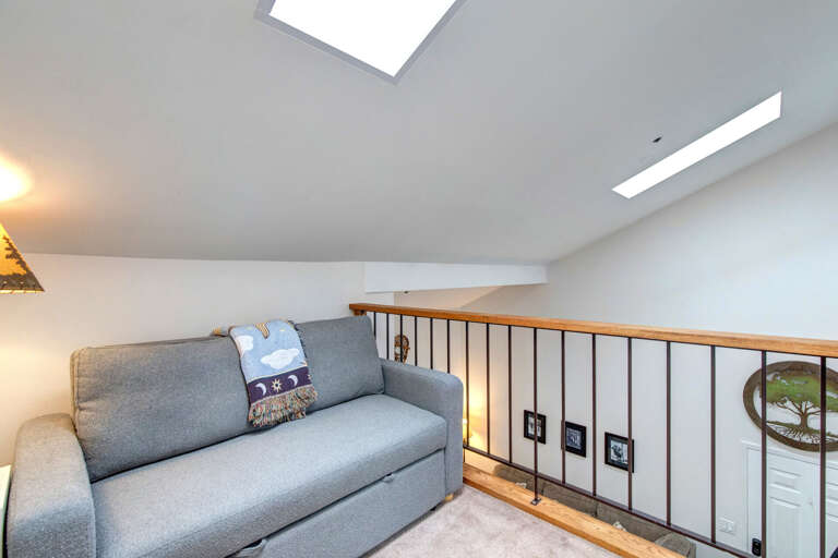 Your private loft retreat features a cozy sofa and skylights flooding the space with natural light, perfect for relaxing after exploring the area.